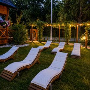 a row of chaise lounges sitting on the grass at Osada Międzywodzie in Międzywodzie