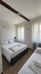 two beds in a bedroom with white walls and windows at Experience Hotel Antico Capon in Venice +15 photos