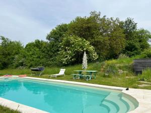 a swimming pool with a table and a picnic table at Dôme en forêt in Saint-Just