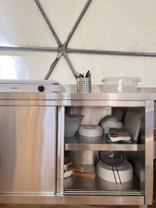 a metal cabinet with plates and dishes in it at Dôme en forêt in Saint-Just