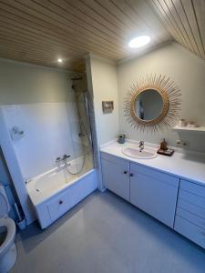 a bathroom with a tub and a sink and a mirror at Charmante maison rénovée in Fernelmont +32 photos