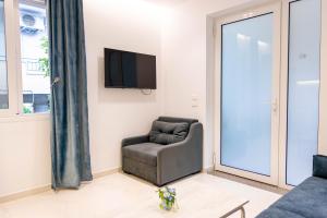 a living room with a chair and a tv at Vila Goxhaj in Sarandë