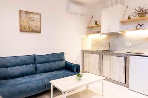 a living room with a blue couch and a table at Vila Goxhaj in Sarandë
