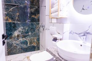 a bathroom with a sink and a toilet and a mirror at Vila Goxhaj in Sarandë +50 photos