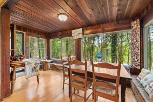 a dining room with a table and chairs and windows at Cozy waterfront cabin with fire pit in Old Hickory