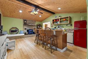 a kitchen with a red refrigerator and a bar with stools at Cozy waterfront cabin with fire pit in Old Hickory
