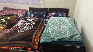 two beds with blankets and pillows in a room at Jhalaram house in Kedārnāth