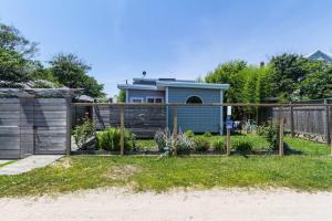 a garden with a fence and a house at The Surfcomber Unit 1 in Ocean Bay Park