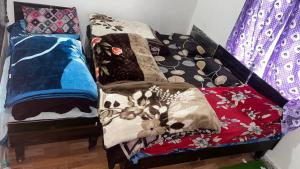 a couch covered in colorful blankets and pillows at Jhalaram house in Kedārnāth