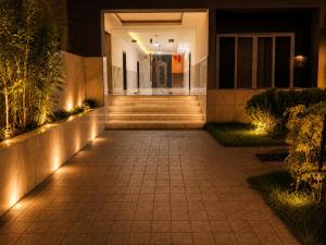 a pathway leading to a house at night with lights at THE POOL LABONE in Accra