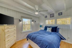 a bedroom with a blue bed and a flat screen tv at The Surfcomber Unit 3 in Ocean Bay Park