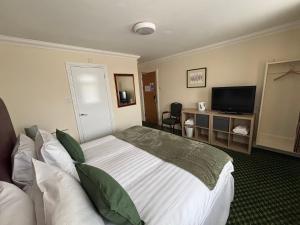 a hotel room with a bed and a television at Granby Hotel in Gravesend