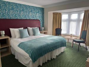 a bedroom with a large bed and blue walls at Granby Hotel in Gravesend