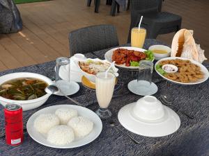 a table with plates of food and drinks on it at Reef Resort - Mount Apo View Unit B2 in Kaputian