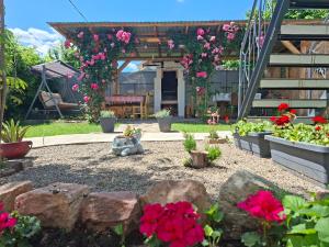 a garden with flowers and rocks in front of a building at Corddora Apartman in Mezőkövesd