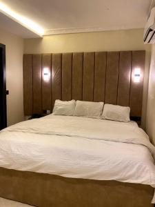 a bedroom with a large bed with a wooden headboard at D' Amex Hotel in Lekki
