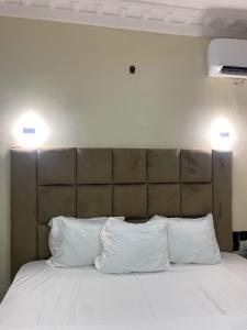 a bed with two white pillows and two lights above it at D' Amex Hotel in Lekki