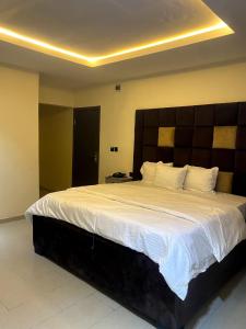 a bedroom with a large bed with a large headboard at D' Amex Hotel in Lekki