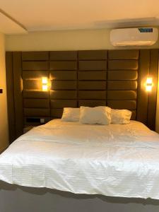 a bedroom with a large white bed with two pillows at D' Amex Hotel in Lekki