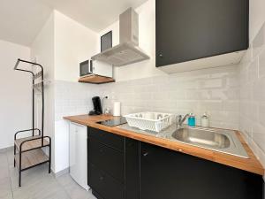 a kitchen with a sink and a microwave at Charmant studio in Plailly