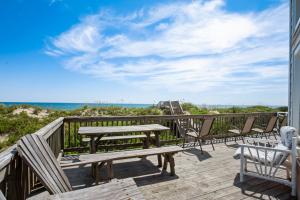 a wooden deck with a picnic table and chairs at 1227 - Seven Shells in Corolla