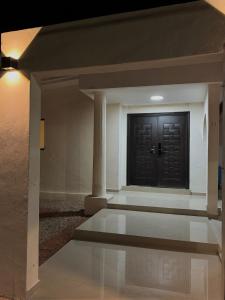 ein Flur mit einer schwarzen Tür und einer Säule in der Unterkunft Casa Arce in Hermosillo
