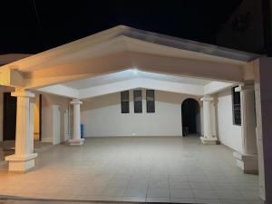 ein großer Raum mit einer weißen Wand und Säulen in der Unterkunft Casa Arce in Hermosillo