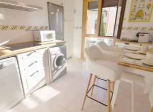 a white kitchen with a washing machine and a table at Dúplex Sierpes centro parking opcional in Salamanca
