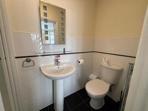 a bathroom with a sink and a toilet and a mirror at Granby Hotel in Gravesend