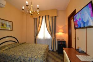 ein Hotelzimmer mit Bett und Fernseher in der Unterkunft Hotel Residence in Parma
