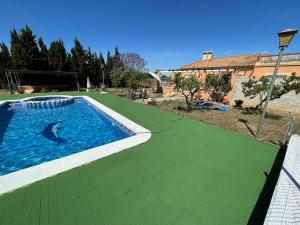 a swimming pool on a green floor next to a house at Mi Cielo in Cartagena