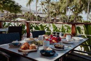 a table with food on top of a balcony at Tahiti Lagoon Resort in Punaauia