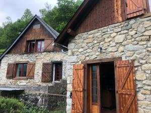 an old stone house with wooden doors and windows at Chalet individuel à Ustou 09 in Ustou