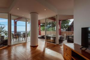 a living room with sliding glass doors and a television at Tahiti Lagoon Resort in Punaauia