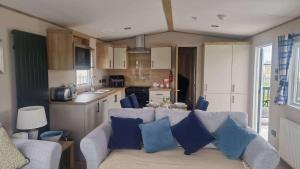 a living room with a couch and a kitchen at 3 Bed - Sleeps 8 - Family & Pet Friendly in Skegness