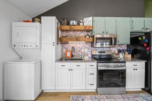 a kitchen with white cabinets and a refrigerator at Round House in Beech Mountain