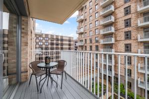 a balcony with a table and chairs on a building at Luxury 2BR Apartment I Sleep 8 I Direct to Wembley & Euston in Hatch End