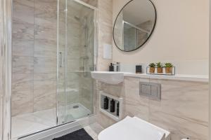 a bathroom with a shower and a sink and a mirror at Luxury 2BR Apartment I Sleep 8 I Direct to Wembley & Euston in Hatch End +5 photos