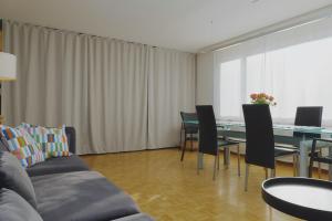 a living room with a couch and a table and chairs at Traumhafte 2,5-Zi-Wohnung -B- mit Sicht auf See und Berge in Alpnach +9 photos