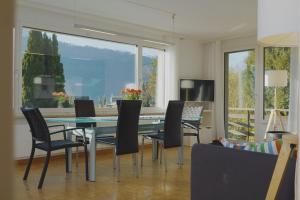 a dining room with a glass table and chairs at Traumhafte 2,5-Zi-Wohnung -B- mit Sicht auf See und Berge in Alpnach