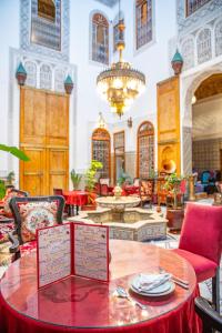a dining room with a table with a menu on it at Riad Iline fes in Fez