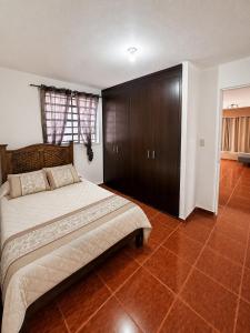 a bedroom with a large bed and a brown cabinet at Casa ejecutiva para 10 personas in Gómez