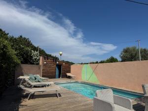 a swimming pool with chairs and a wooden deck at Camping les Lauriers Roses in Fréjus