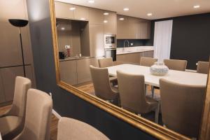 a room with a table and chairs and a mirror at Royal Galla Apartment in Macedo de Cavaleiros