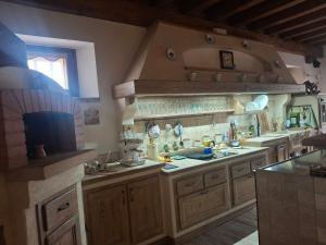 a large kitchen with wooden cabinets and a sink at Il Pozzo dei desideri Shabby in Spilimbergo