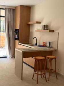 a kitchen with a counter with two stools and a sink at Piknik Suites in Dhërmi +14 photos