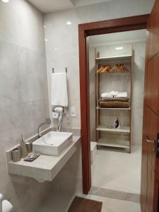 a bathroom with a sink and a shelf with towels at Flat Sognare Uno in Santa Teresa