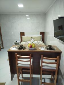 a table with two chairs and a bowl of fruit on it at Flat Sognare Uno in Santa Teresa +8 photos