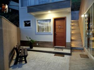 a front door of a house with a bench and stairs at Flat Sognare Uno in Santa Teresa