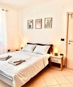 a white bedroom with a large bed and two lamps at Zen Suite in Umag +9 photos